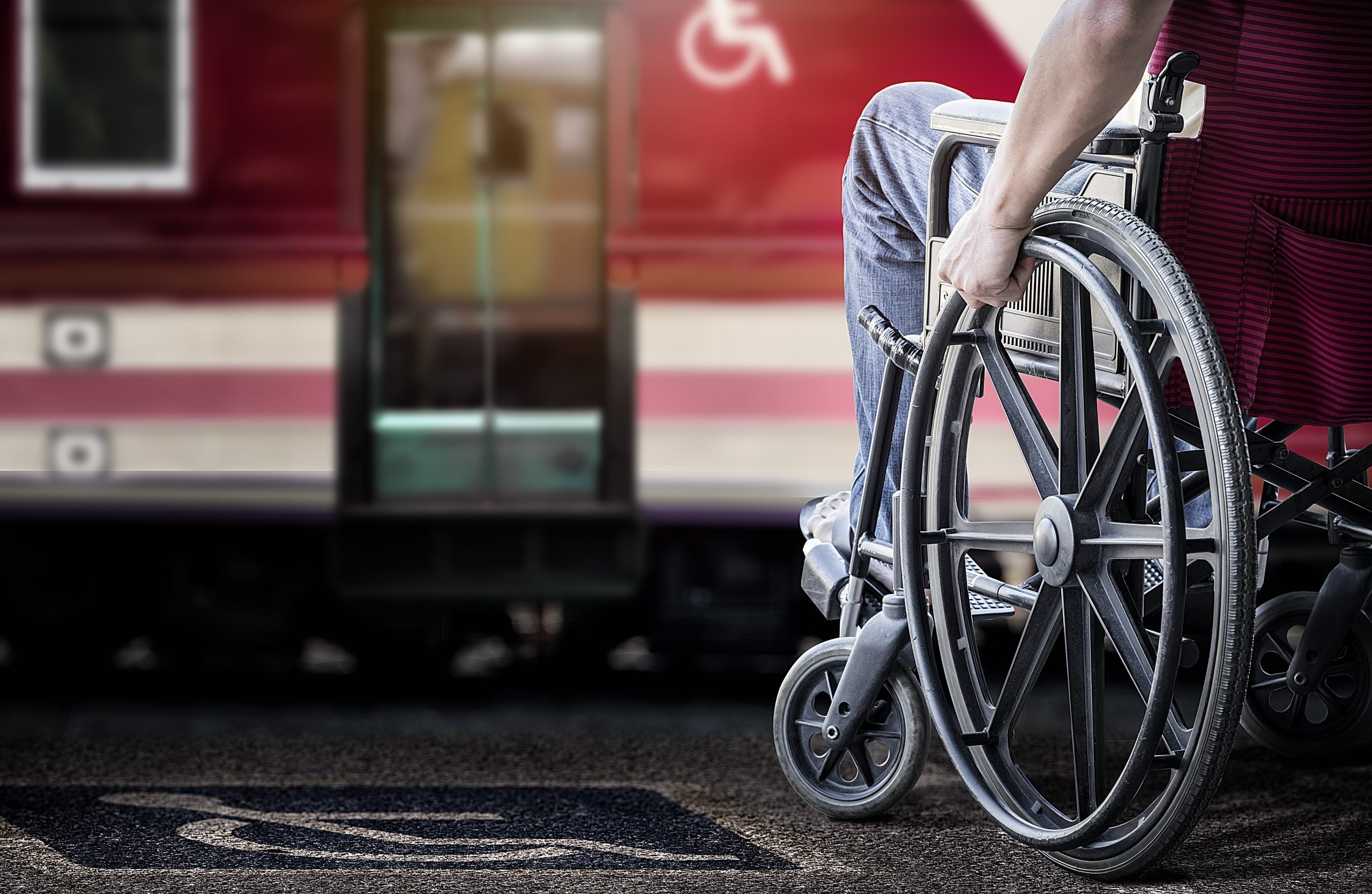 Cropped image of man in his wheelchair at railway station platform waiting for train
